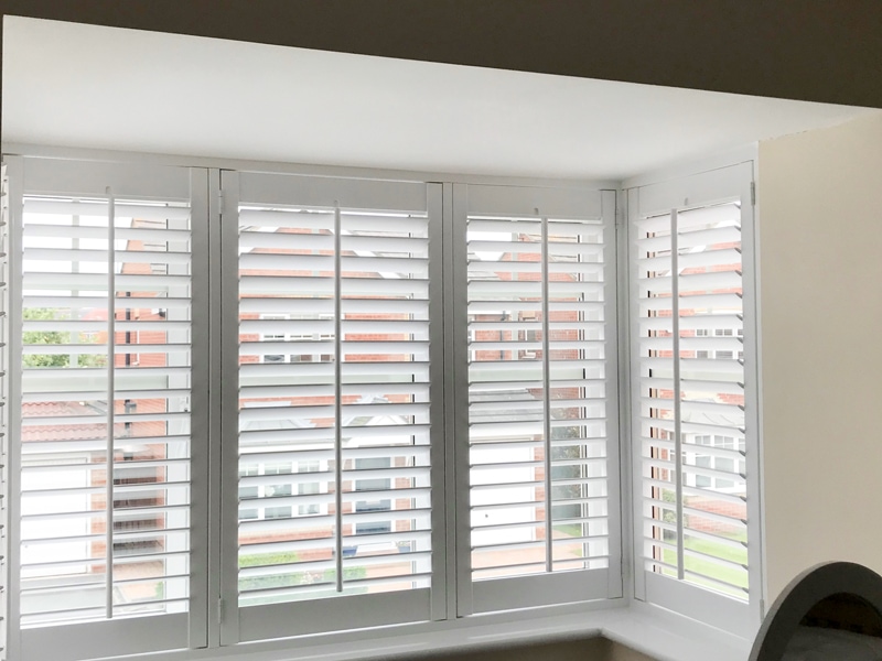 White plantation shutters custom-fit window treatment enhancing home style and value.