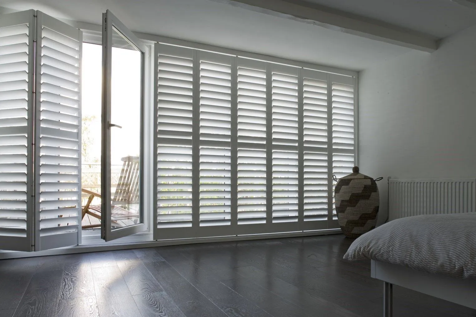White plantation shutters and open doorway showcasing light control and home elegance.
