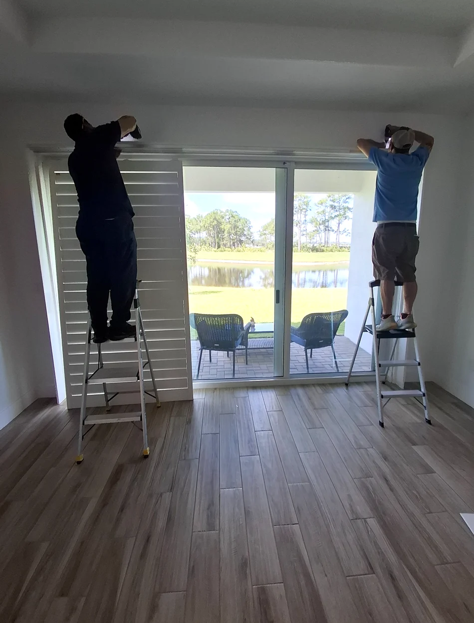 Liberty Shutters installers professionally installing sliding glass door shutters