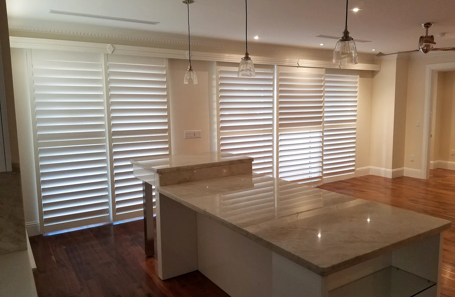 Wide sliding glass door plantation shutters in a modern living area